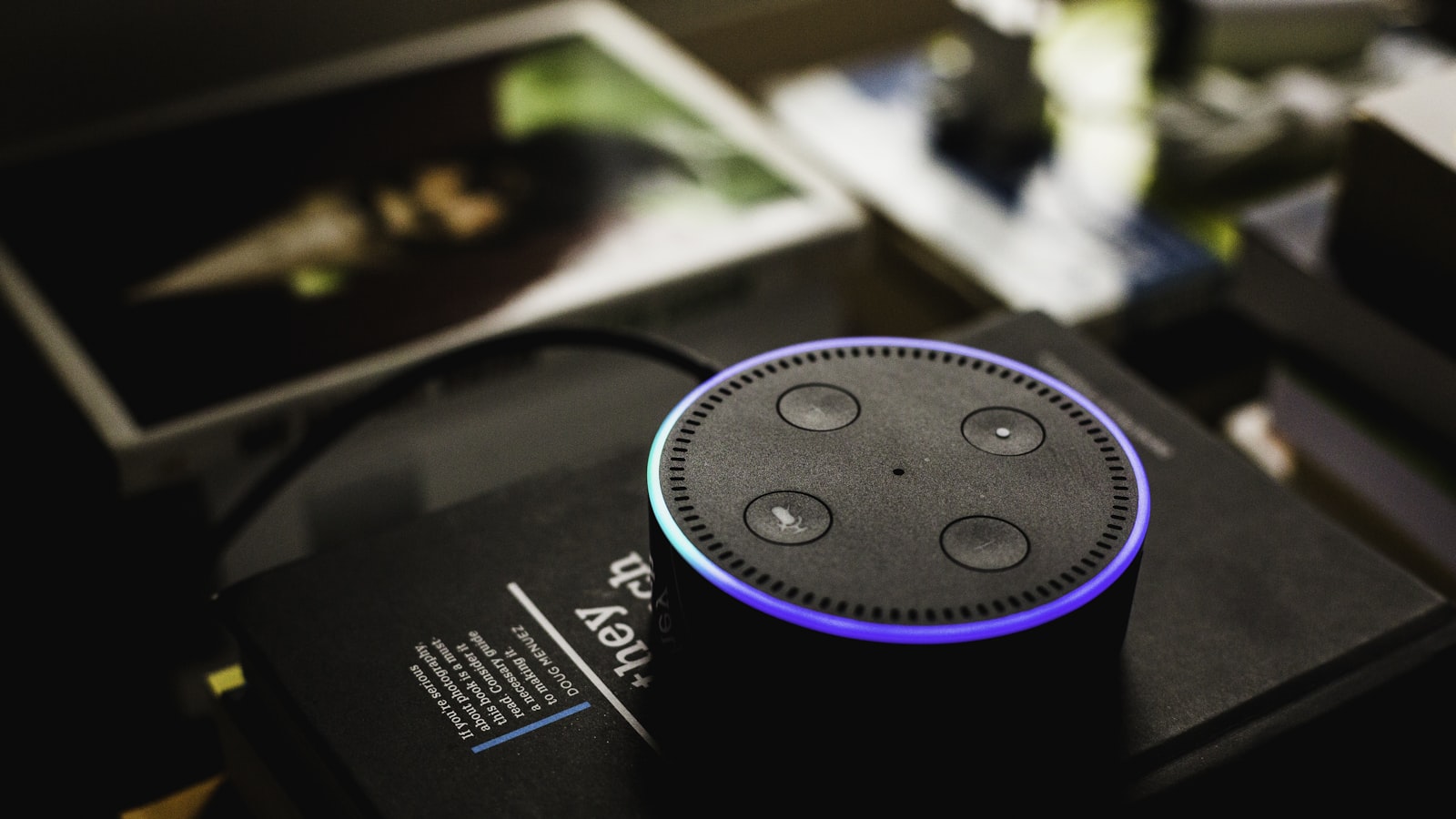 A voice-controlled smart speaker on a wooden table.