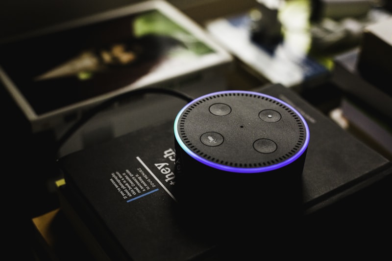 A voice-controlled smart speaker on a wooden table.