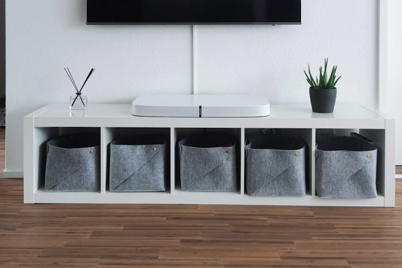 A voice-assistant smart speaker on a shelf in a living room.