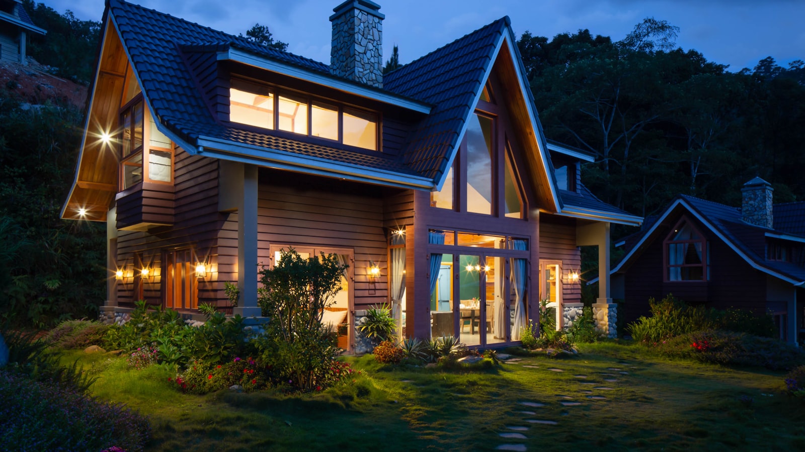 A modern house with large windows seen at dusk.