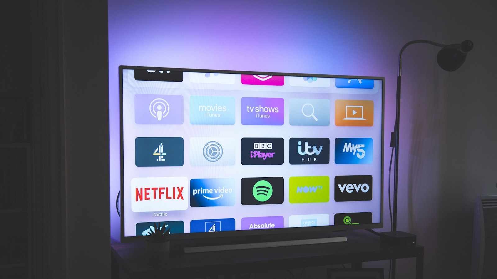 A smart speaker and hub on a shelf at home.